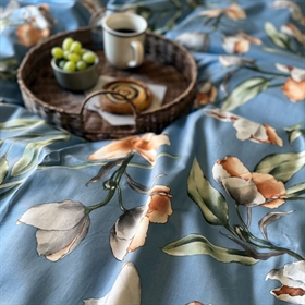Luna Denmark sengesættet har et smukt print af smukke blomster blomster på en blå baggrund.