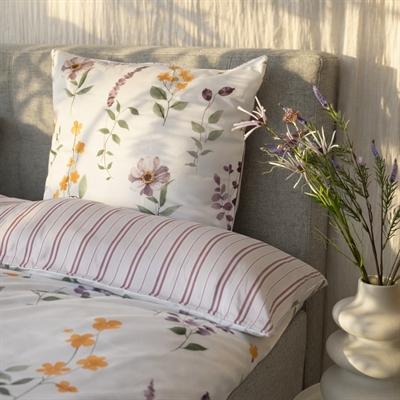 blomstret og stribet sengetøj rosa på redt seng