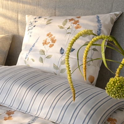 Blomst og stribet sengetøj på redt seng Blå